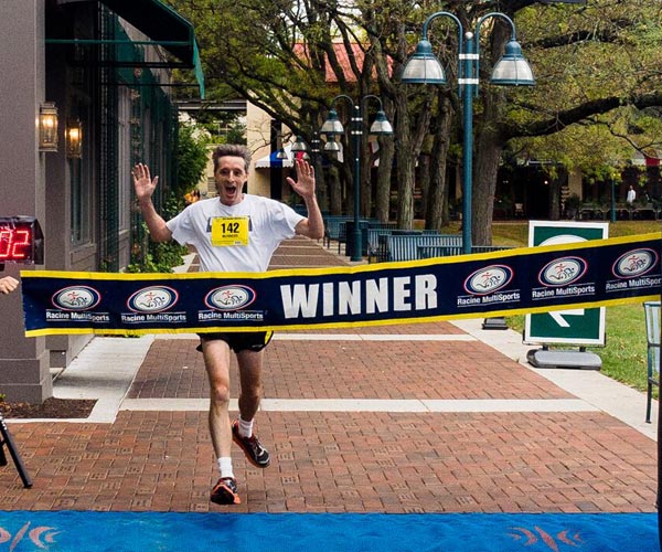 A man running across the finish line of a race.