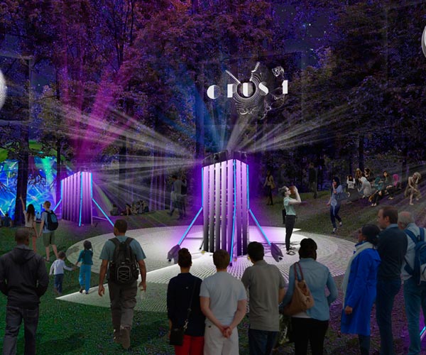 A group of people standing around in front of a light show.