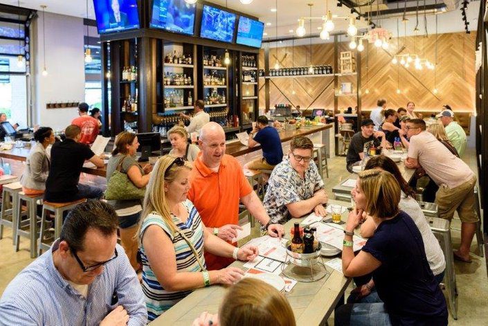 A group of people sitting at tables in a restaurant.