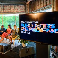 A television screen with the merriweather artists residence district logo on it.